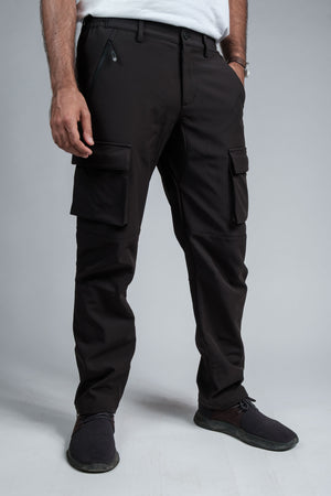 Person wearing black cargo pants on a gray background